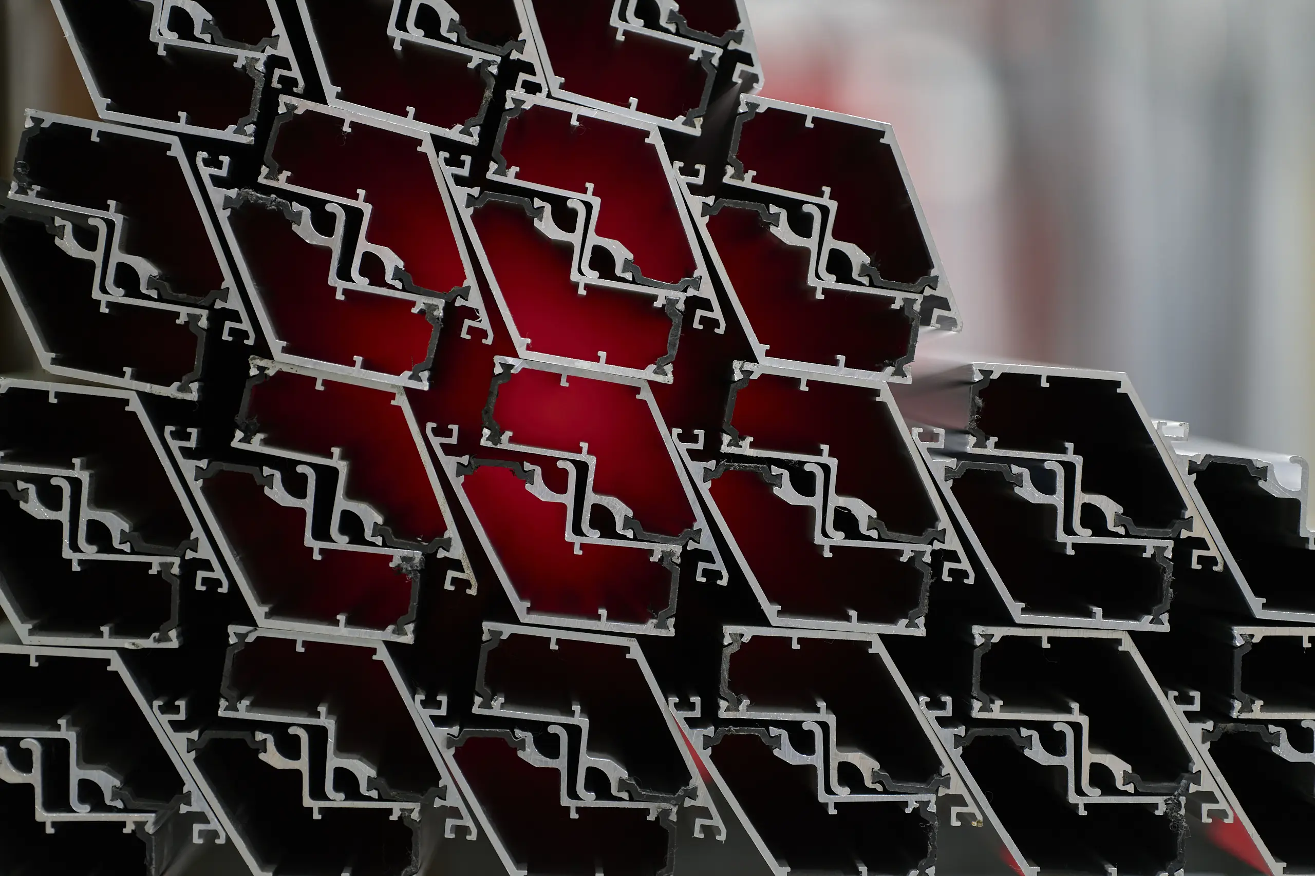 Raw aluminium profiles - Stacked aluminium extrusions ready for fabrication and finishing.